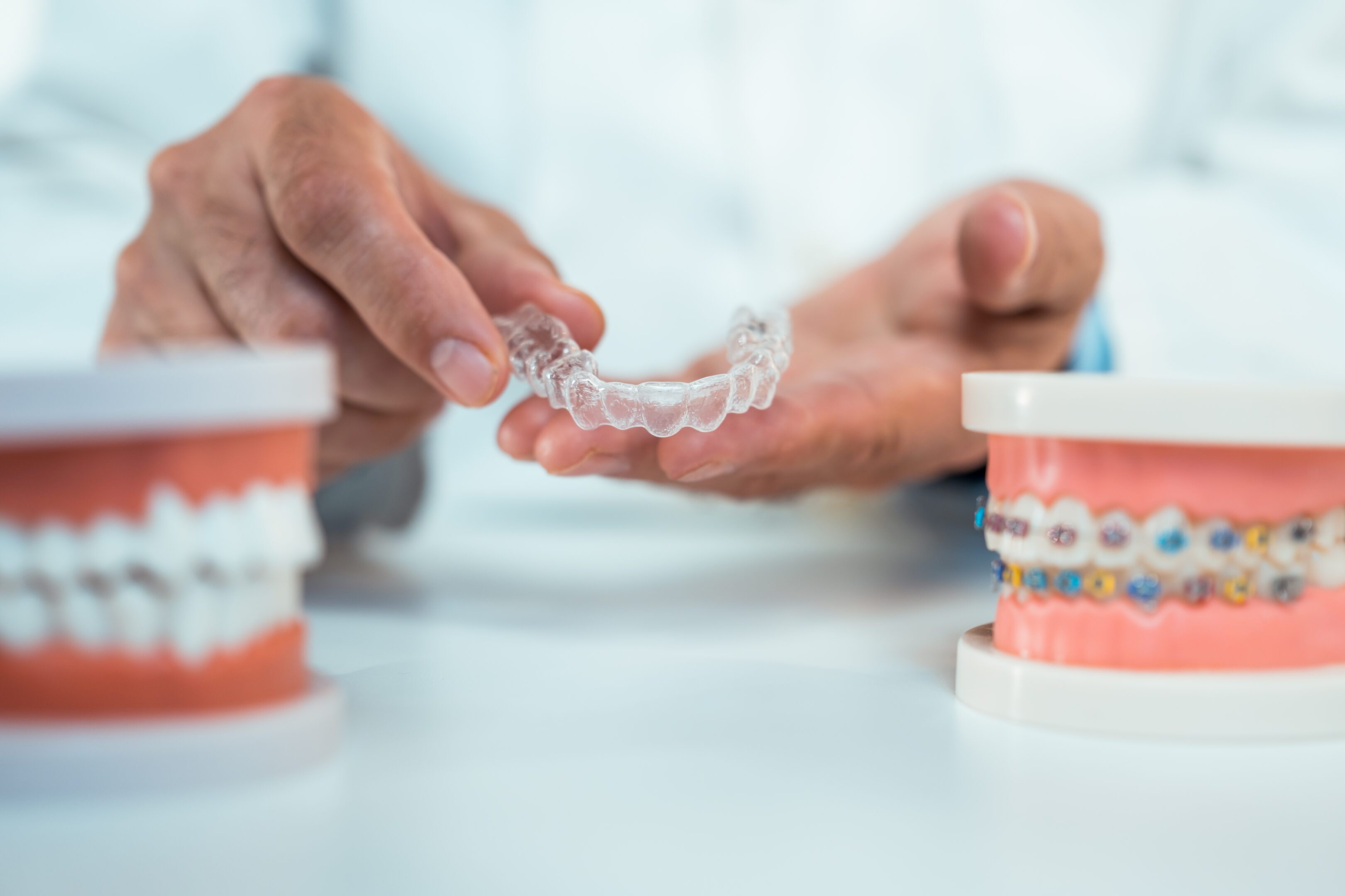 Hands holding clear dental aligner